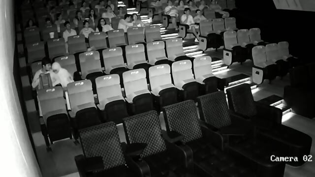 A couple having sex in front of everyone in a cinema hall
