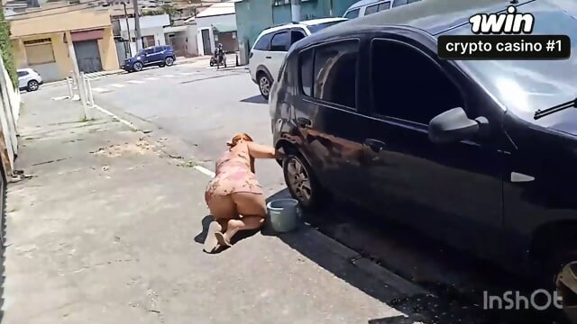 Uma mulher voluptuous lava o carro e se exibe na rua de forma provocante.