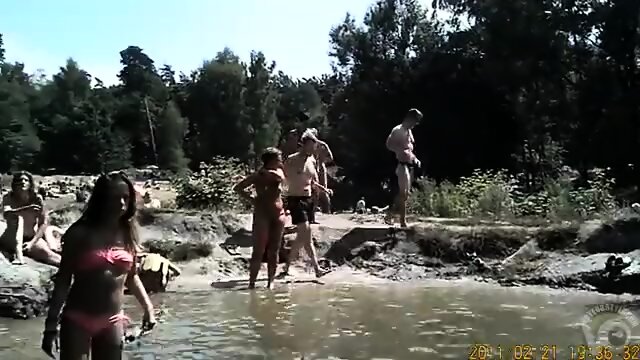 Nudist camp at the lake with lots of men and women